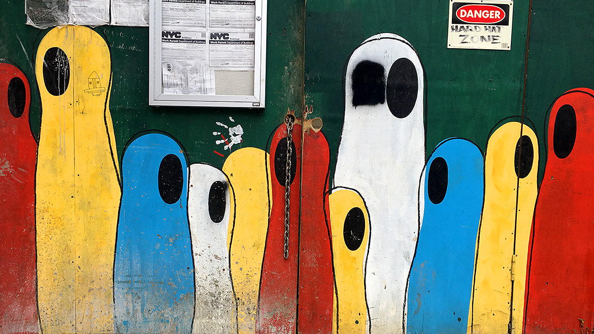 colorful one eyed ghosts painted on a construction site