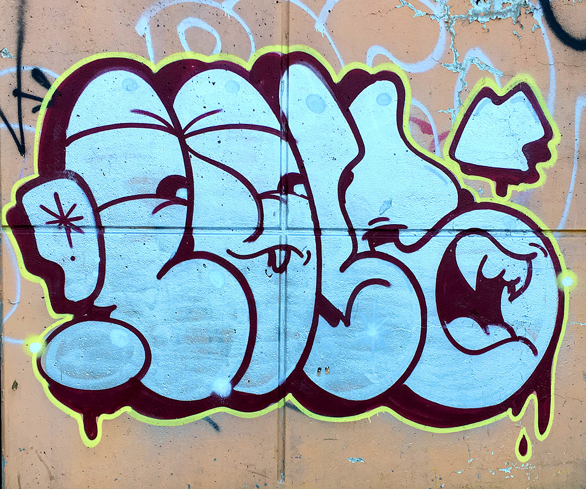 Spray paint graffiti lettering with fangs illustrated inside the letters