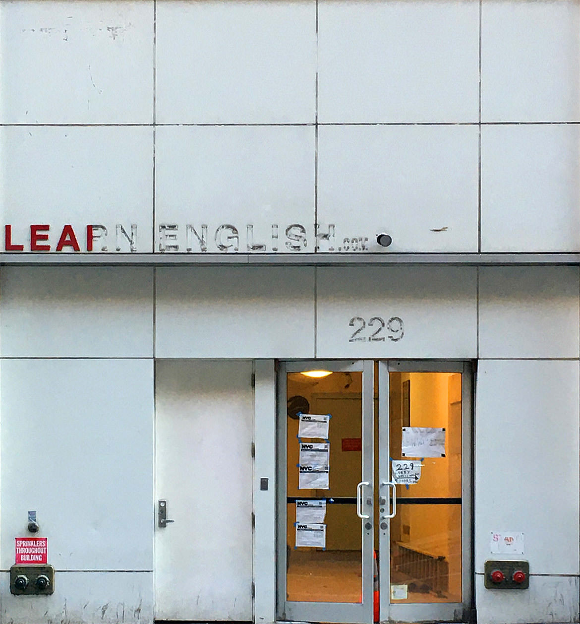 A faded building with the phrase "Learn English" falling off the front.