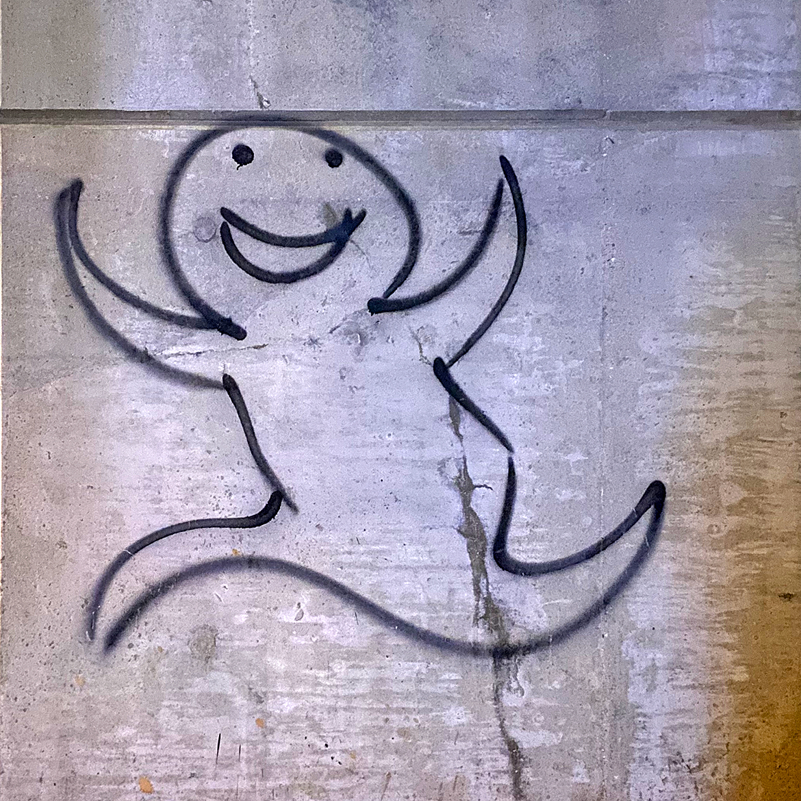 Spray paint graffiti of a smiling happy ghost skipping along in a single black line