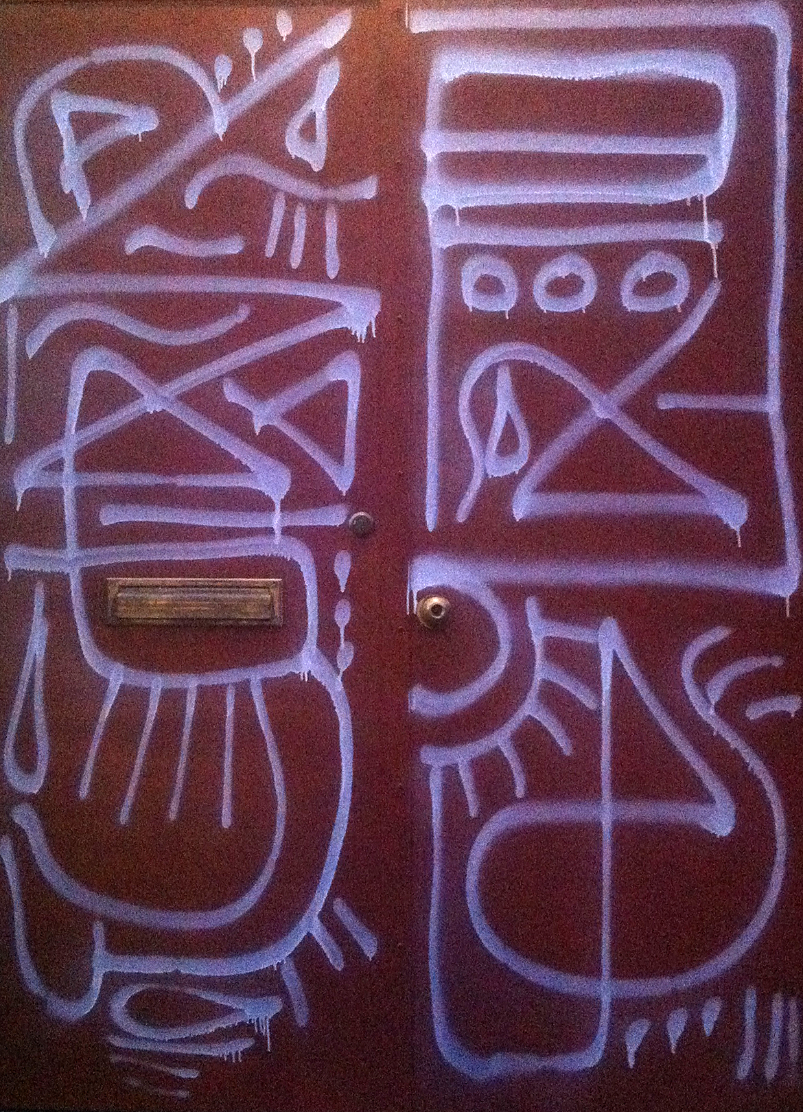 Red door with white spray paint pattern grafitti
