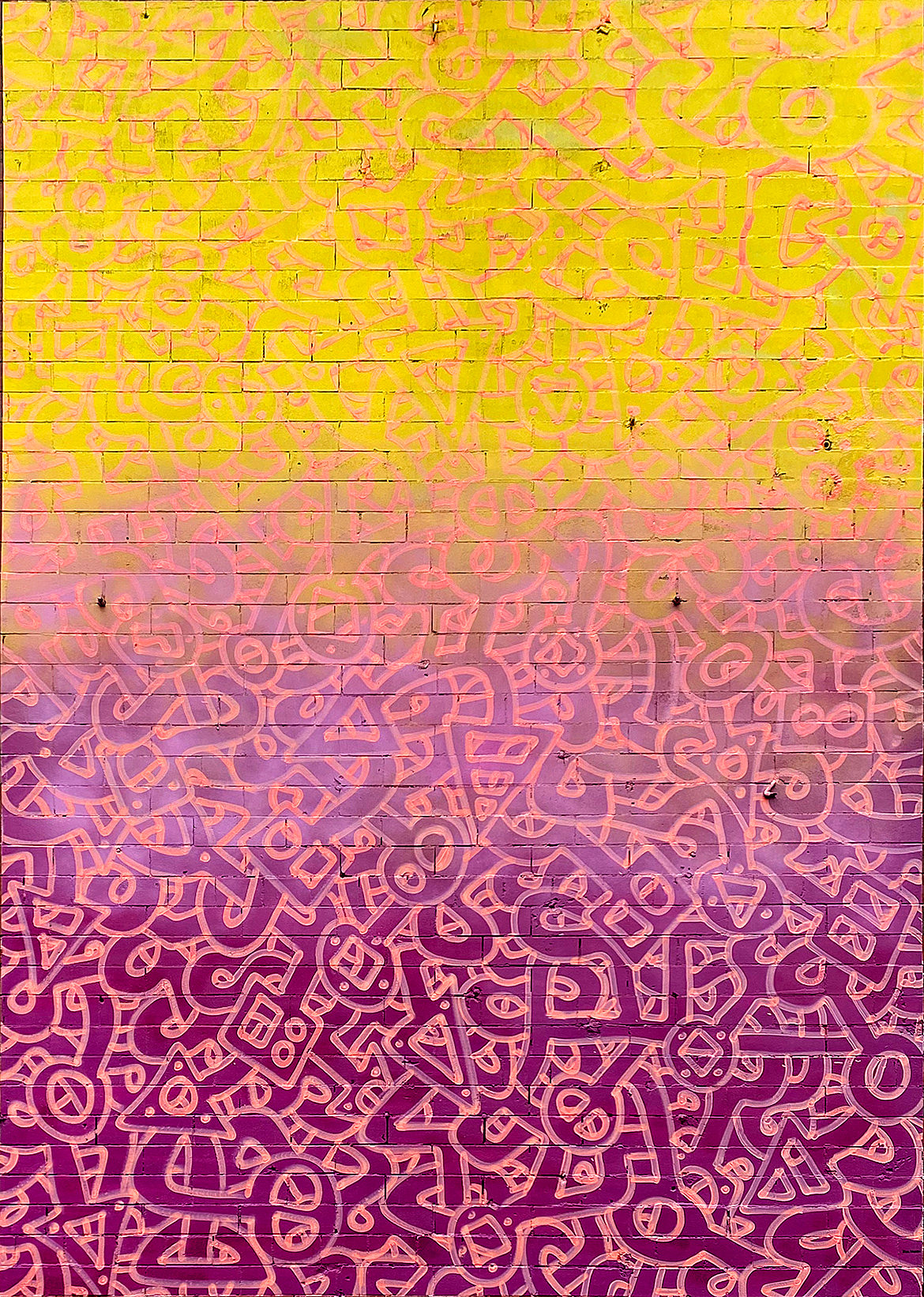 A mural with a background of yellow at the top fading to purple at the bottom and intricate interlocking shapes painted within