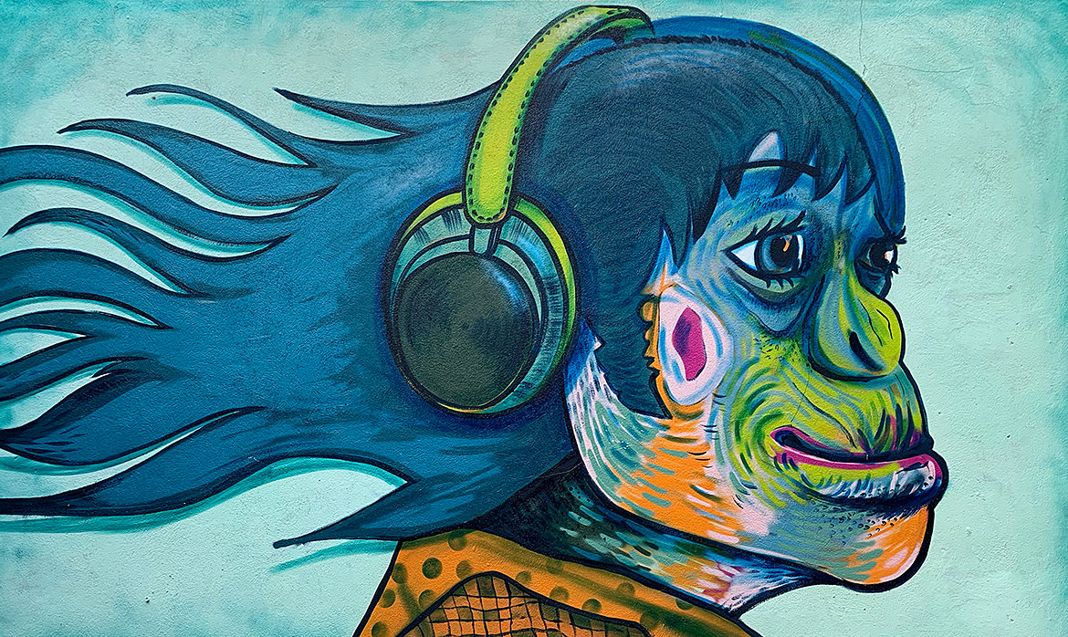 A mural painting of an female ape wearing headphones and smiling