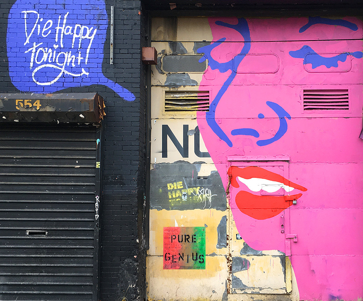 Mural of a woman's face with a speech bubble saying "Die happy tonight"