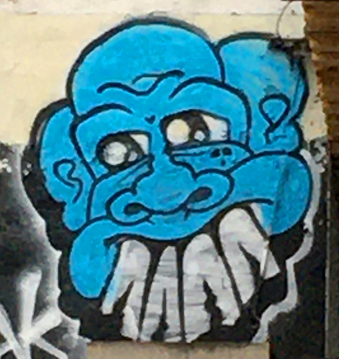 Spray paint graffiti blue cartoon face with large white buck teeth