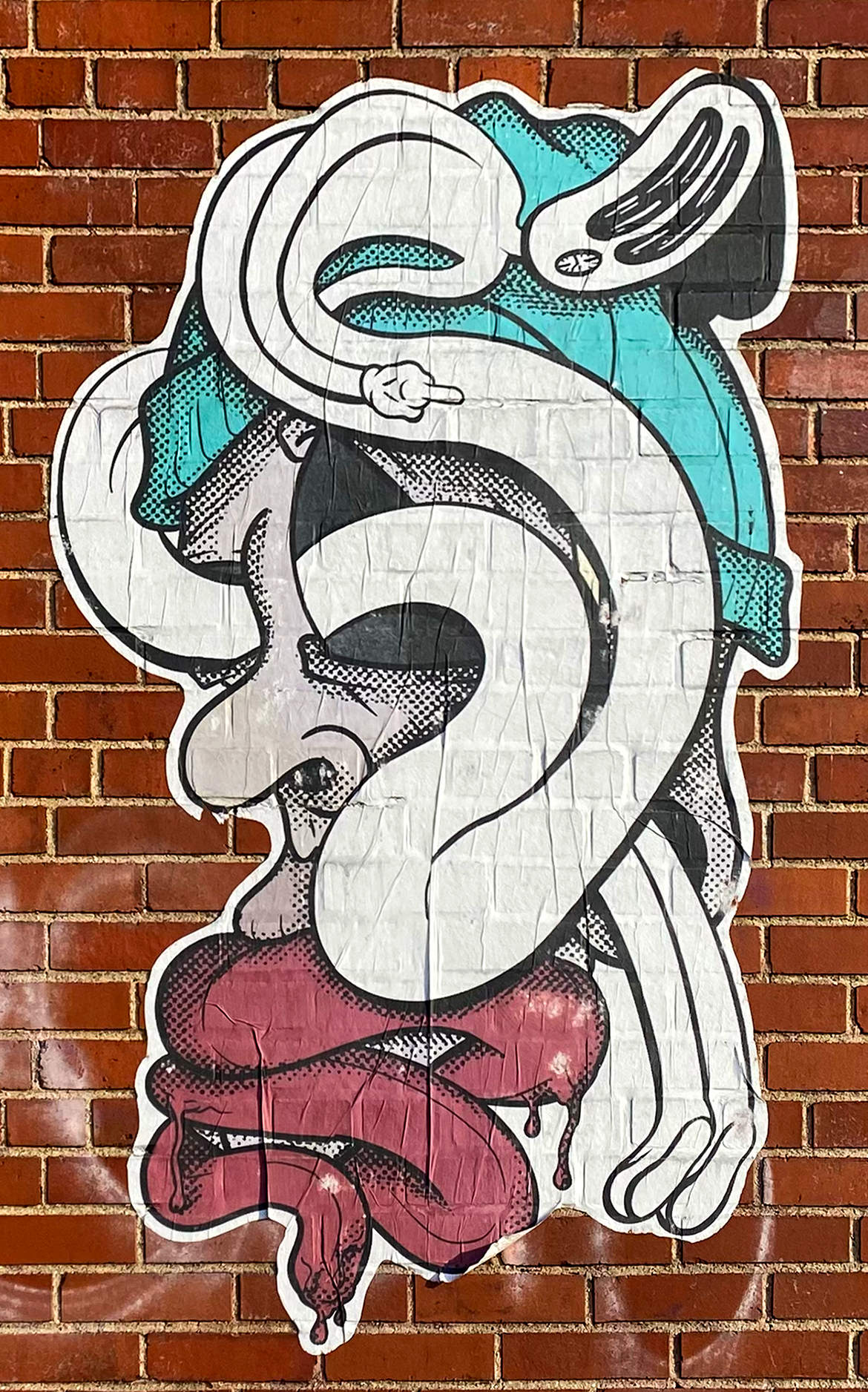 A large wheat pasted illustration of a ghost weaving through the ear and eyes of a man wearing a blue beanie